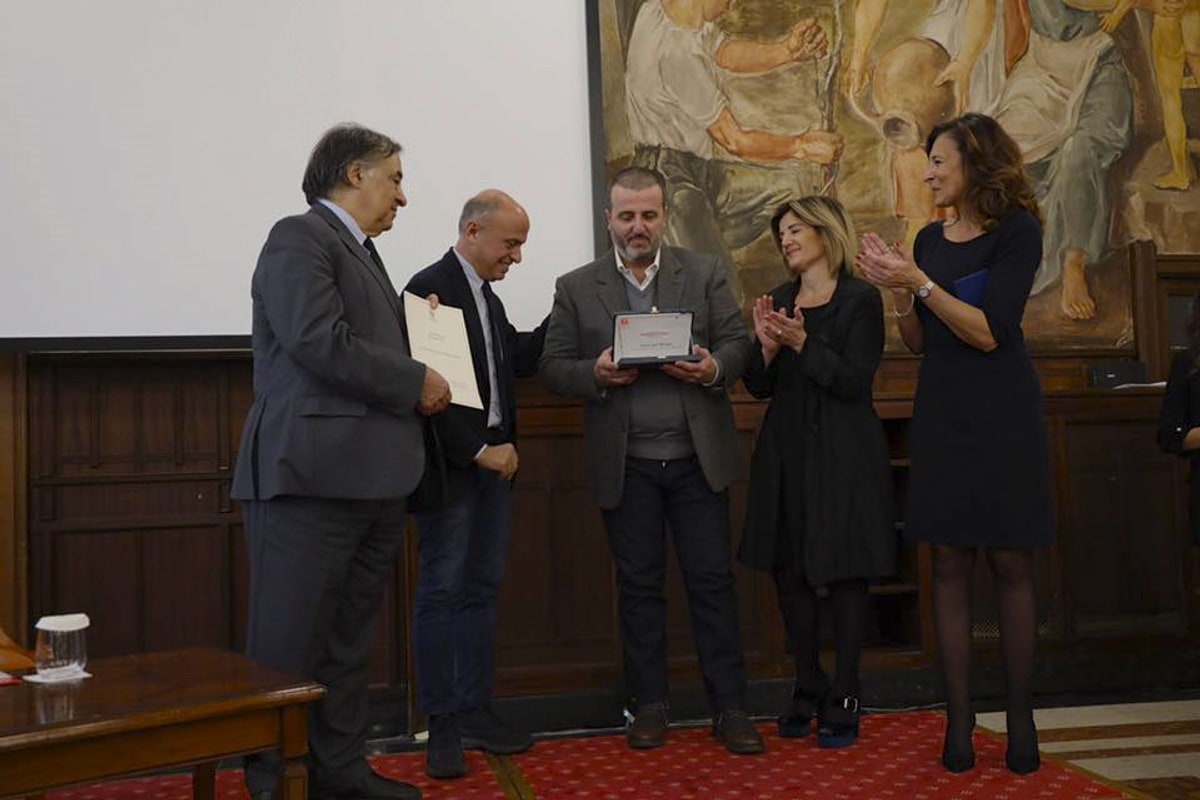 Consegna di una targa e di un attestato in una sala istituzionale